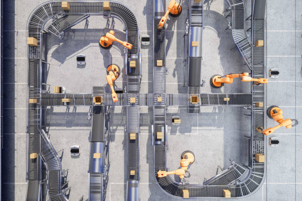 Overhead view of robotic arms moving boxes along a factory conveyor